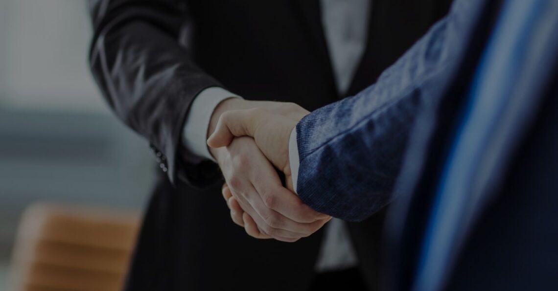 Aperto de mão entre cliente e consultor da Estrategor, simbolizando uma parceria de sucesso na gestão de benefícios fiscais e incentivos.