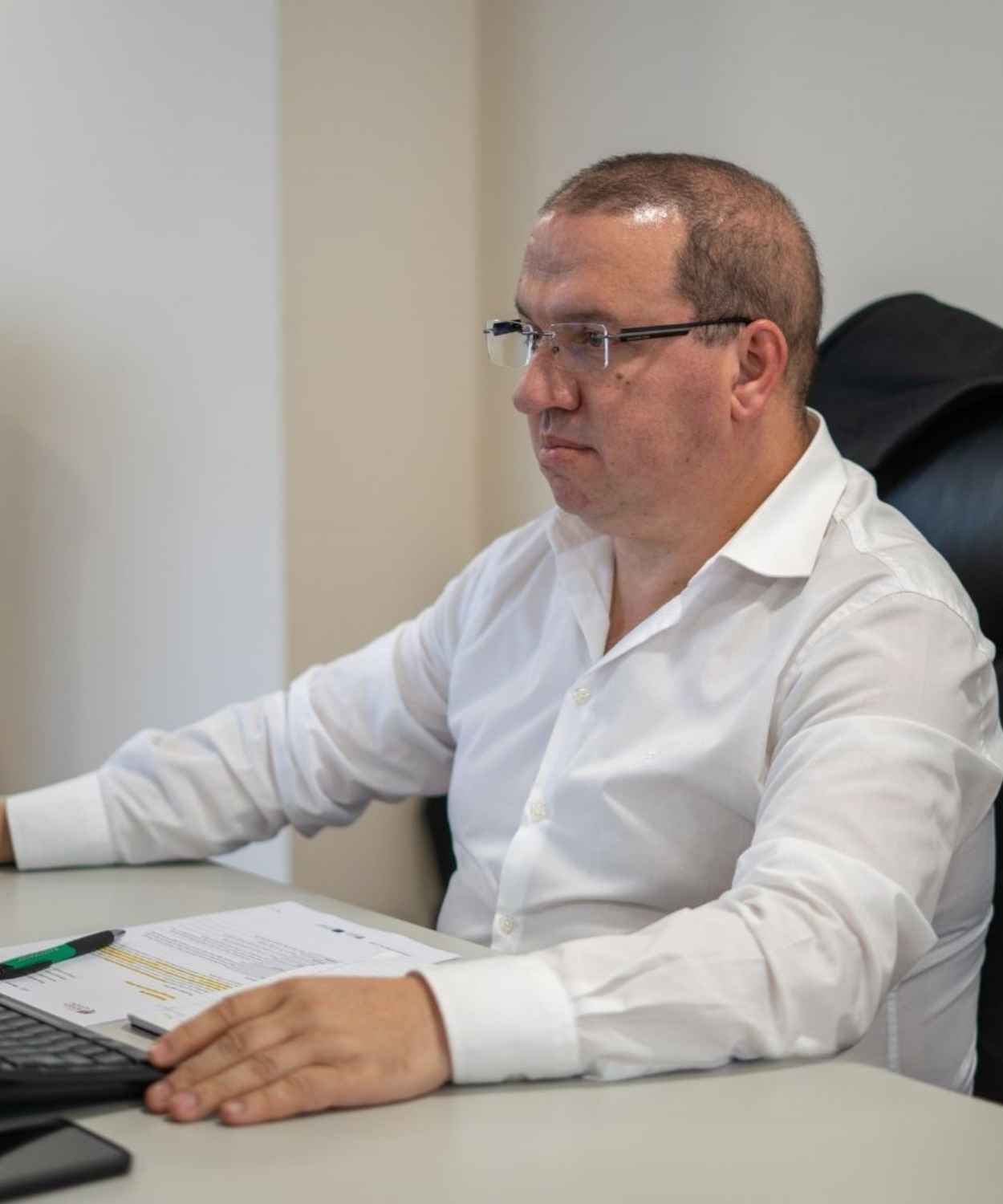 Controller Jerónimo Rocha a analisar relatórios financeiros e documentação em papel.