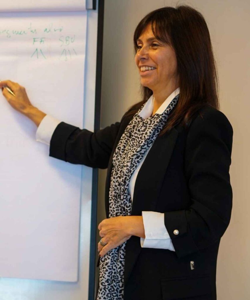 Maria Pinto, gestora de formação, a apresentar conceitos num flipchart durante uma sessão de formação.