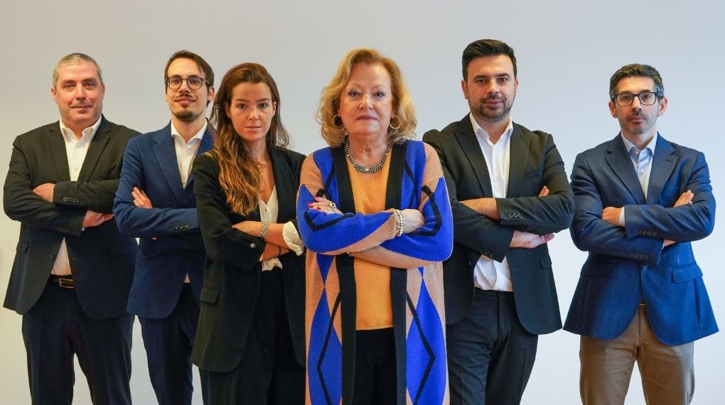 Retrato corporativo da equipa de gestão e consultoria da Estrategor, com seis profissionais em pose executiva, liderados por uma figura central feminina, transmitindo confiança e profissionalismo.